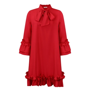 Detail of red long sleeve dress showing bow tie neckline and tiered ruffle trim details