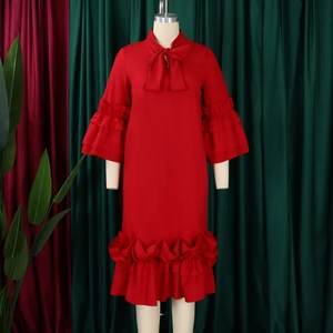 Detail of red dress featuring elegant tie-up bow neckline and layered ruffle bell sleeves