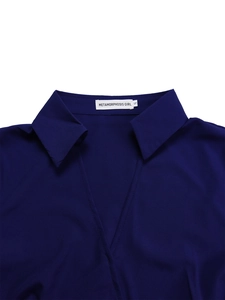 Detail of the V-neckline and branding label on a dark blue short-sleeved dress