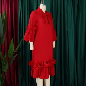 Detailed view of the red chiffon dress featuring ruffle sleeves and a bow tie neckline