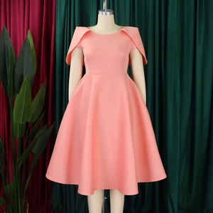 Détail d'une robe trapèze rouge corail avec manches cape élégantes sur mannequin