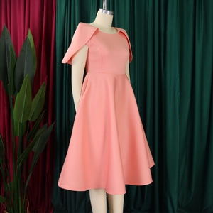 Détail d'une robe mi-longue rose pêche avec manches cape élégantes et silhouette trapèze