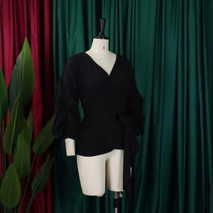 Detail of black V-neck puff sleeve blouse with adjustable waist tie on a mannequin