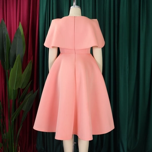 Détail de la robe rose corail avec col cape et taille ajustée sur un mannequin