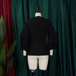 Detailed back view of textured black puff sleeves with pleated structure on a mannequin