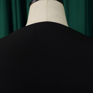 Detail of V-neck collar and shoulder tailoring on a sleek black puff sleeve blouse