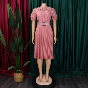 Detail of pink dress featuring delicate lace bodice with pleated skirt and metallic belt