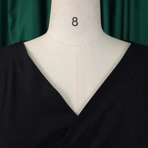Close-up of deep V-neckline and textured fabric on a stylish black puff sleeve top