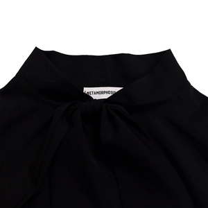 Detail of elegant black dress neckline with tied bow and textured fabric finish