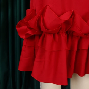 Detail of red tiered ruffle hem with pleated edges and tiny decorative beads