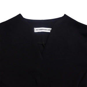 Gros plan sur l'élégant col en V noir avec texture de tissu et étiquette de marque