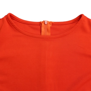 Detailed neckline view of an orange pleated dress featuring a back invisible zipper