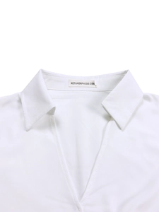Close-up of white dress shirt sharp collar and V-neckline with brand label detail