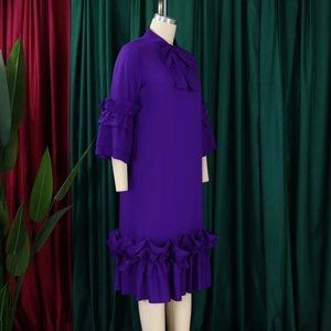 Detail of elegant pussy-bow neckline and layered ruffle sleeves on dark purple dress