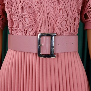 Detail of pink lace bodice and pleated skirt with leather D-buckle belt on a dress