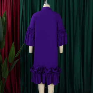 Detail of elegant purple dress showing ruffled bell sleeves and layered pleated hemline