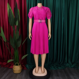 Detail of fuchsia pleated dress with intricate floral lace stitching and a buckled belt