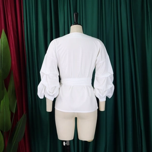 Back view of a white puff sleeve shirt with lace-up waist design on a mannequin