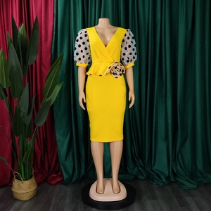 Detail of yellow V-neck pencil dress with sheer polka dot puff sleeves and floral waist decoration