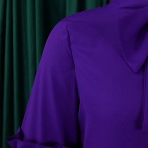 Detailed close-up of purple chiffon top featuring bow tie collar and ruffle cuffs