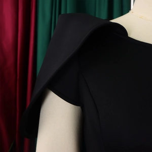Vue macro détaillée de l'épaule structurée sur cette élégante robe noire chic