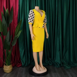 Detail of elegant V-neck yellow dress featuring sheer mesh polka dot puff sleeves and waist flower