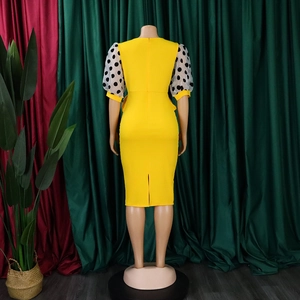Back view of yellow pencil dress featuring polka dot mesh puff sleeves and a split hem
