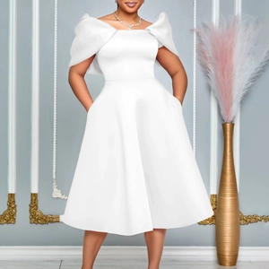 Détail de la robe en satin blanc avec épaules dénudées, poches latérales et nœud élégant
