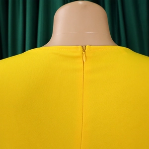 Close-up of invisible back zipper and stitching on bright yellow puff sleeve pencil dress