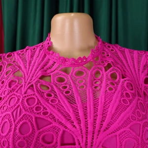 Detail of fuchsia lace dress featuring intricate geometric patterns and scalloped neckline
