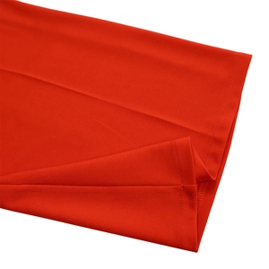 Detail shot of bright red jumpsuit hem with precision stitching and soft cotton texture