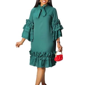 Close-up of elegant dark green dress featuring tiered ruffle bell sleeves and soft fabric