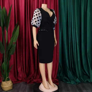 Detail of elegant pencil dress featuring sheer white polka dot puff sleeves and V-neckline