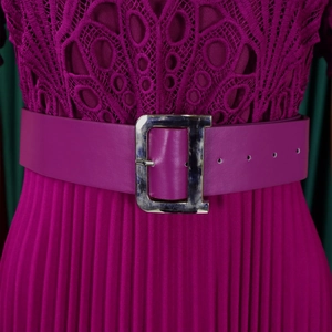 Detail of fuchsia lace bodice and pleated skirt with metal letter D buckle belt