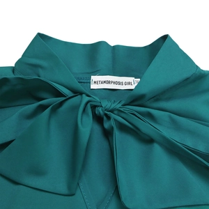 Detail view of dark green dress neckline featuring a large bow and brand size label