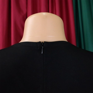 Detail view of the concealed back zipper on a black textured pencil dress