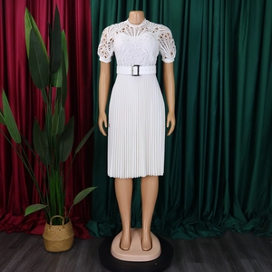 Detailed view of white dress with intricate lace bodice and pleated accordion skirt with belt