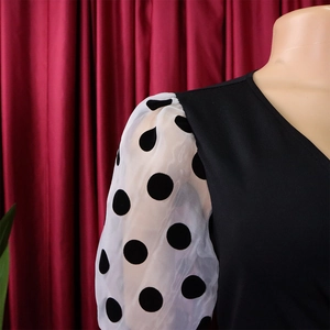 Detail of contrast puff sleeves with black polka dots on a stylish pencil dress