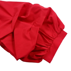 Detail of red puffed sleeve featuring intricate pleats and premium woven texture