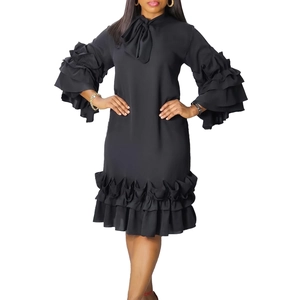 Close-up of black dress featuring tiered ruffle sleeves and elegant neck bowtie detail