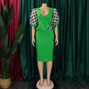 Detail of elegant green V-neck dress with mesh polka dot puff sleeves and floral waist decor