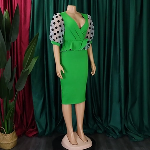 Close-up of V-neck dress with polka dot mesh puff sleeves and peplum waist detail
