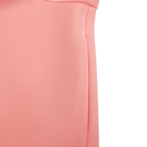 Détail du tissu rose en maille montrant la couture de qualité et la texture douce