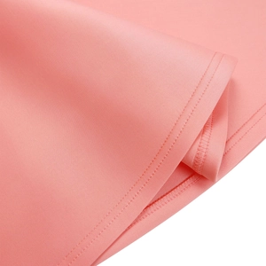 Gros plan sur un tissu en maille rose avec double couture précise et texture délicate