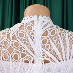 Detail of white hollow lace top with geometric patterns and back invisible zipper