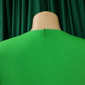 Close-up of invisible zipper closure on the back of a bright green mesh sleeve dress