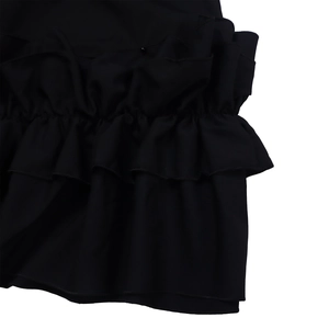 Detail view of layered black ruffles and soft draped fabric on this stylish dress