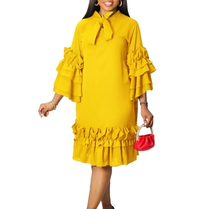 Detail of elegant bright yellow dress with ruffled sleeves and bow neck design