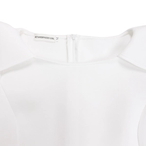 Détail de la robe blanche présentant une fermeture éclair au dos et l'étiquette de marque