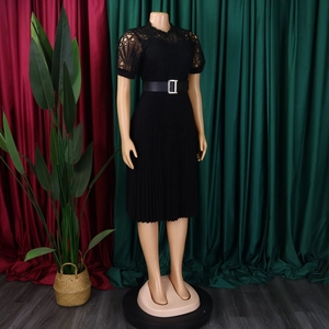 Detail of black dress featuring intricate lace bodice, buckled belt, and pleated skirt